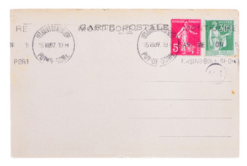 Vintage yellowed postcard back side, circa 1937, with old french post and meter stamps, with text Postcard and name of french village Mont Dore, isolated on white background