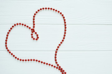 Red heart of beads on a white background
