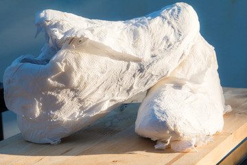 Sneakers wrapped in tissue paper, was taken to dry after washing.