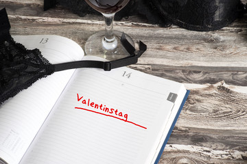 Dessous, Weinglas und ein Kalender mit dem Valentinstag