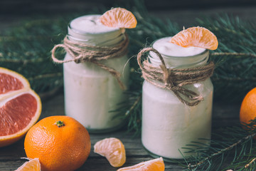 Natural yougurt in jars with tangerine, red orange and fir branc