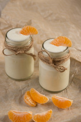 Organic yougurt with fresh tangerine in glass jars