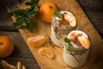 Fresh organig natural white yogurt in glass jars with tangerine