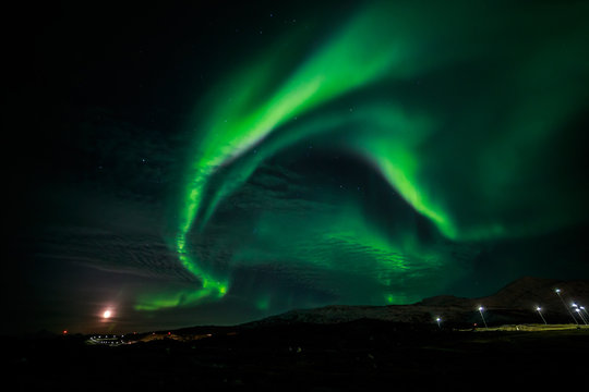 Northern lights and the rising Moon nearby Nuuk city, Greenland