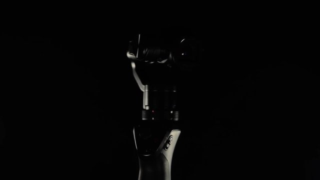 Portable video camera lens with electronic stabilizing system Close up footage. Camera on black background.