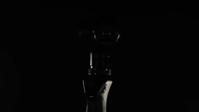 Portable video camera lens with electronic stabilizing system Close up footage. Camera on black background.