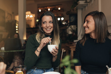 Two beautiful women drinking coffee and chatting.