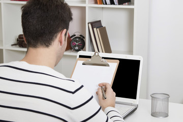 young man studying or working in the home or office with laptop computer