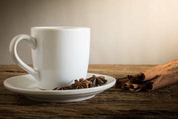 coffee cup, cinnamon sticks on wooden table