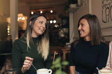Two beautiful women drinking coffee and chatting.