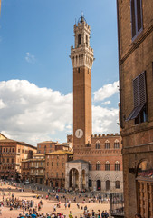 Fototapeta premium Siena, Italy - Oct 3, 2016. View of Palazzo Pubblico in Piazza del Campo with many visitors.
