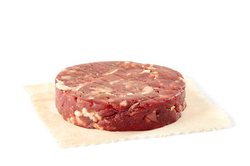 Raw beef burger patty on white