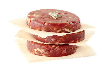 Stack of raw beef burger patties on white