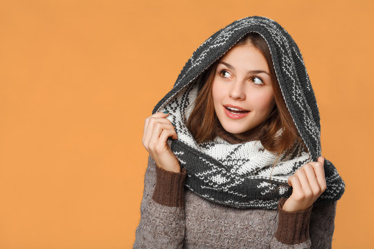 Surprised christmas girl wearing knitted wear scarf. Excited beautiful smiling girl, winter concept, isolated