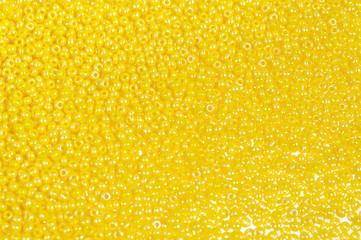 Yellow glass beads background - closeup beads texture