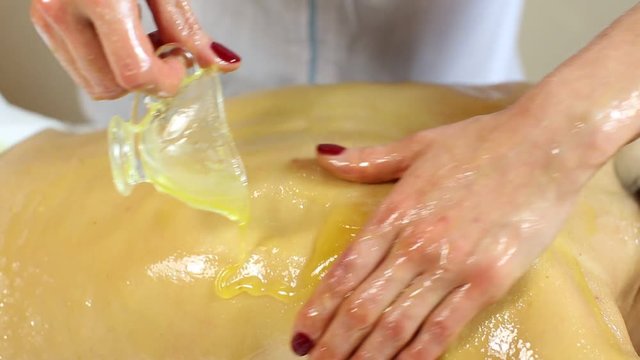 Girl treatment massage honey body wrap in a beauty salon