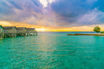 Beautiful water villas in tropical Maldives island at the sunset