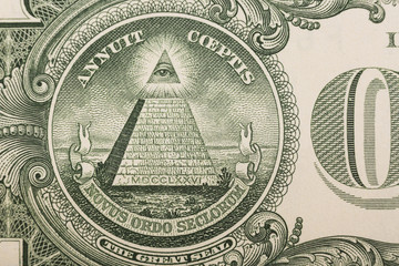 Close up of the pyramid and eye on the back of a one dollar bill