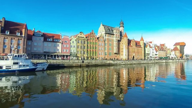 Colourful historic houses and famous crane Polish Zuraw in Old Town of Gdansk, Poland. View from Motlawa river (Time Lapse)