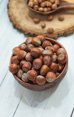 Fototapeta premium hazelnuts in the shell in brown clay bowl