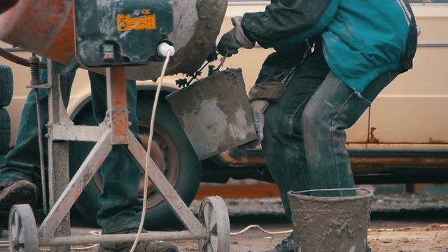 Concrete Mixer Builders and People Working at a Construction Site. Slow Motion