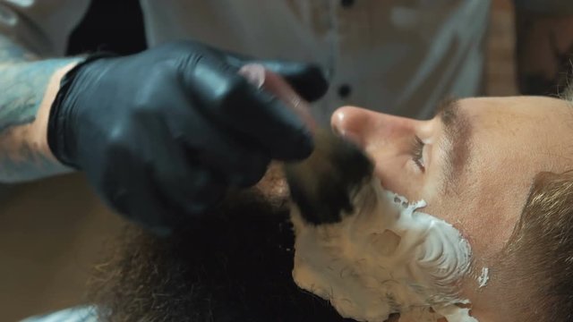 Barber cutting bearded brutal man, barber shop salon