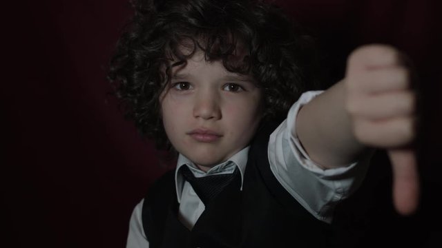 4k Shot of a Cute Businessman Child Showing Thumb Down (focus on boy)