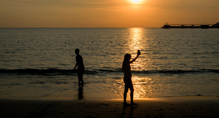 Fototapeta premium People walk ocean beach sunset