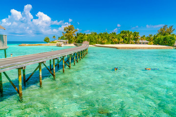 Beautiful water villas with couple snorkeling  in tropical Maldi