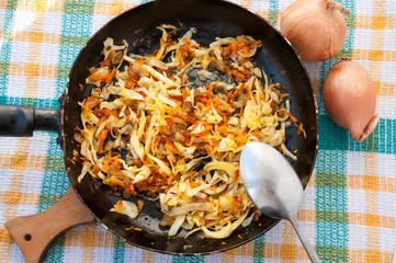 Spoon over pan of cabbage with carrots  