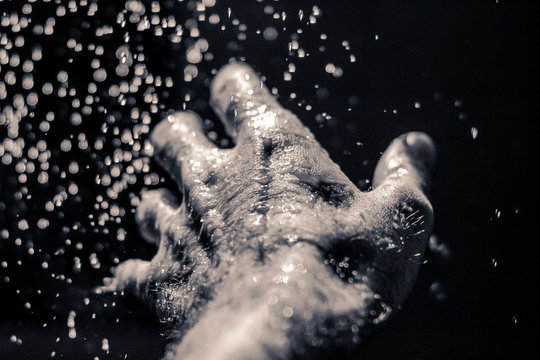 Open human hand under water drops