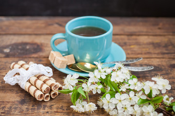wafers, flowers of cherry and tea on a table, selective focus, the image it is tinted