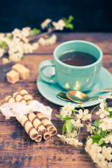 wafers, flowers of cherry and tea on a table, selective focus, the image it is tinted
