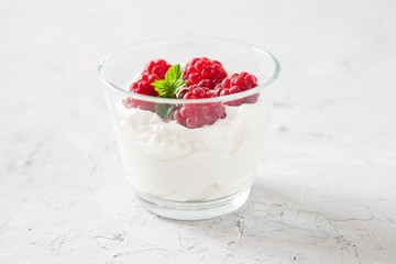 cottage cheese and raspberry in a bowl on a table, selective focus