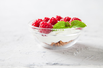 muesli, cottage cheese and raspberry in a bowl on a table, selective focus