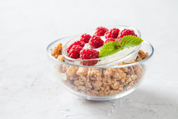 muesli, cottage cheese and raspberry in a bowl on a table, selective focus