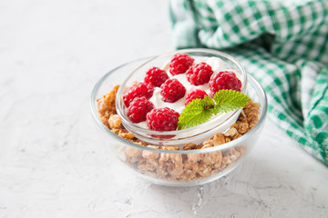 muesli, cottage cheese and raspberry in a bowl on a table, selective focus
