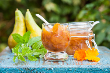 jam from a pear in a jar on a table in a garden, selective focus