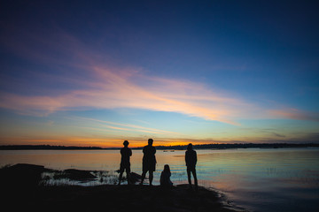 4 people look at sunset in dam