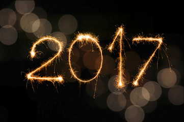 Happy New Year 2017 written with Sparkle firework and colorful lights bokeh background