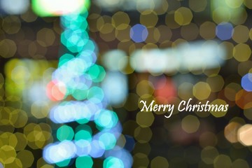 Blur colorful Christmas tree background with merry Christmas text