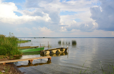 Fototapeta na wymiar Пустые рыбацкие лодки стоят около берега