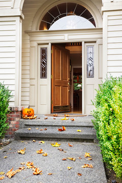 Front path, steps and open front door with fall leaves and jack-o