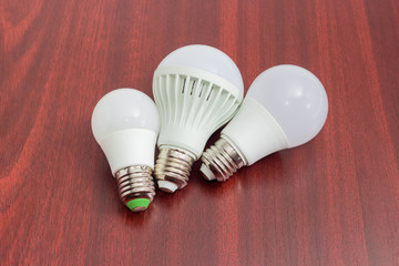 Three different light emitting diode lamp on a wooden surface