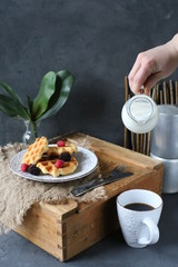 Breakfast waffles with fresh berries stacked on a plate