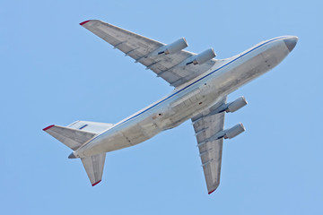 An-124-100 Ruslan (Condor) the world largest cargo strategic airlift jet airplane flies against blue sky background
