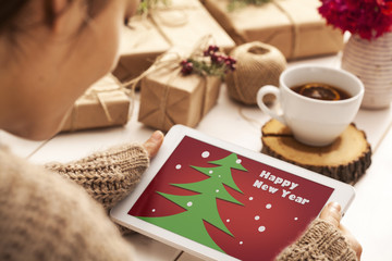 Woman using tablet with gift boxes