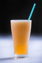 cold melon smoothie in a glass with a straw