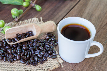 Fresh coffee beans on wood and coffee cup