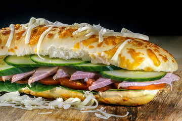 Closeup of Burger on a wooden board with dark background